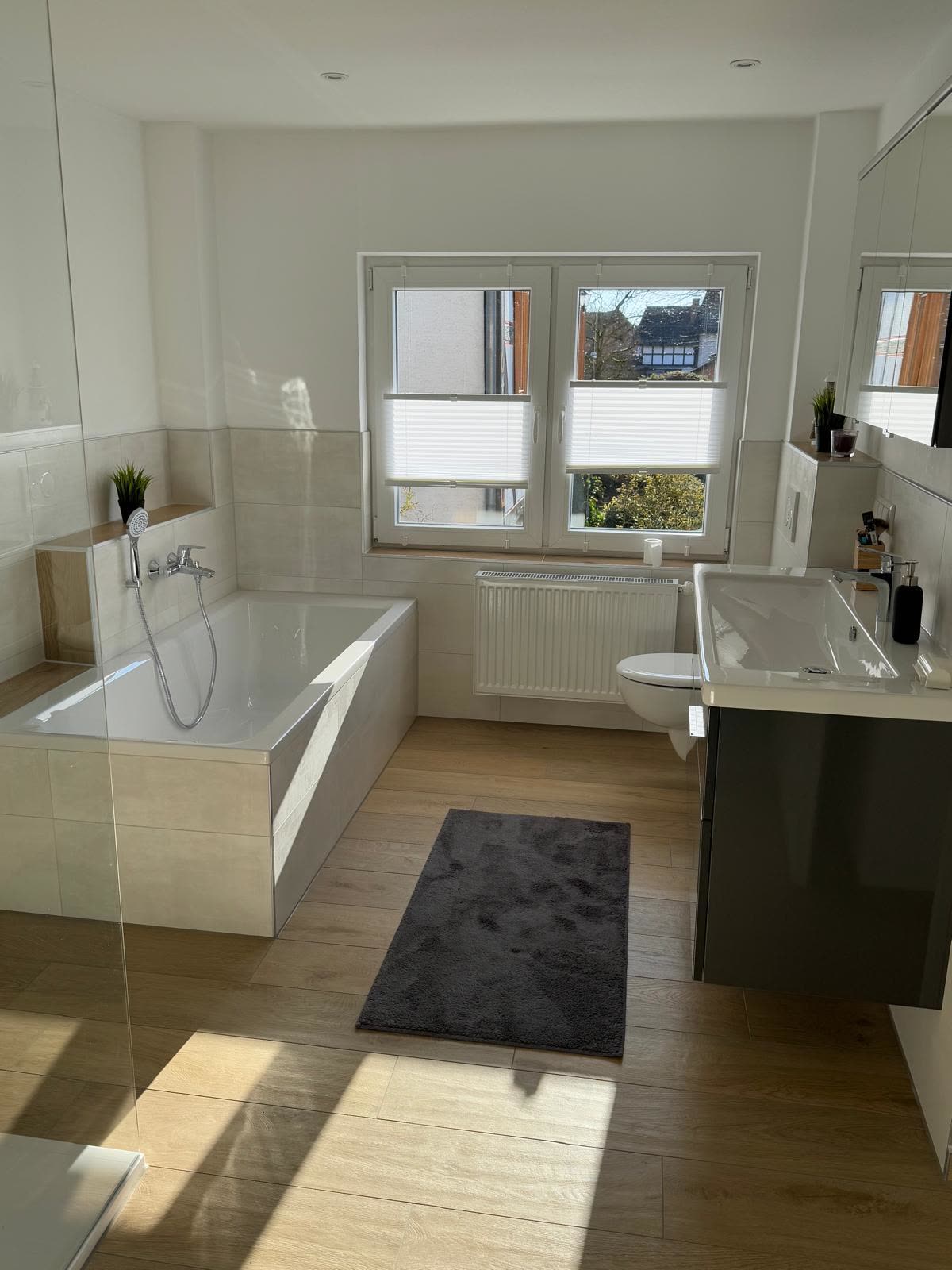 Fertiges Badezimmer mit Wanne und Holzoptik-Boden